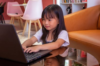 Bilgisayar kullanarak çalışan bir kız. Çocuk cevabı yazıyor ve onu öğretmene yolluyor. Bir çocuk kafede dizüstü bilgisayarla oynuyor..