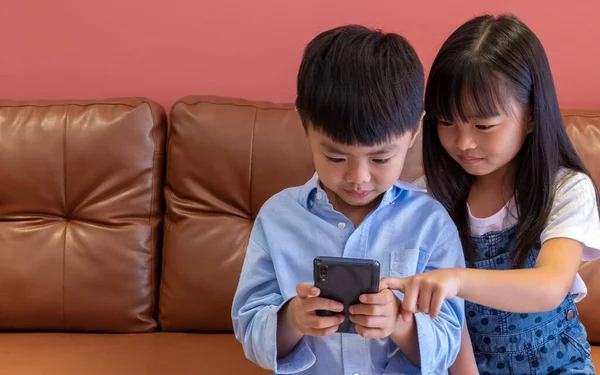 Girl and boy are playing on the phone. girl and boy are playing mobile games. Girl and boy student are studying online by phone.