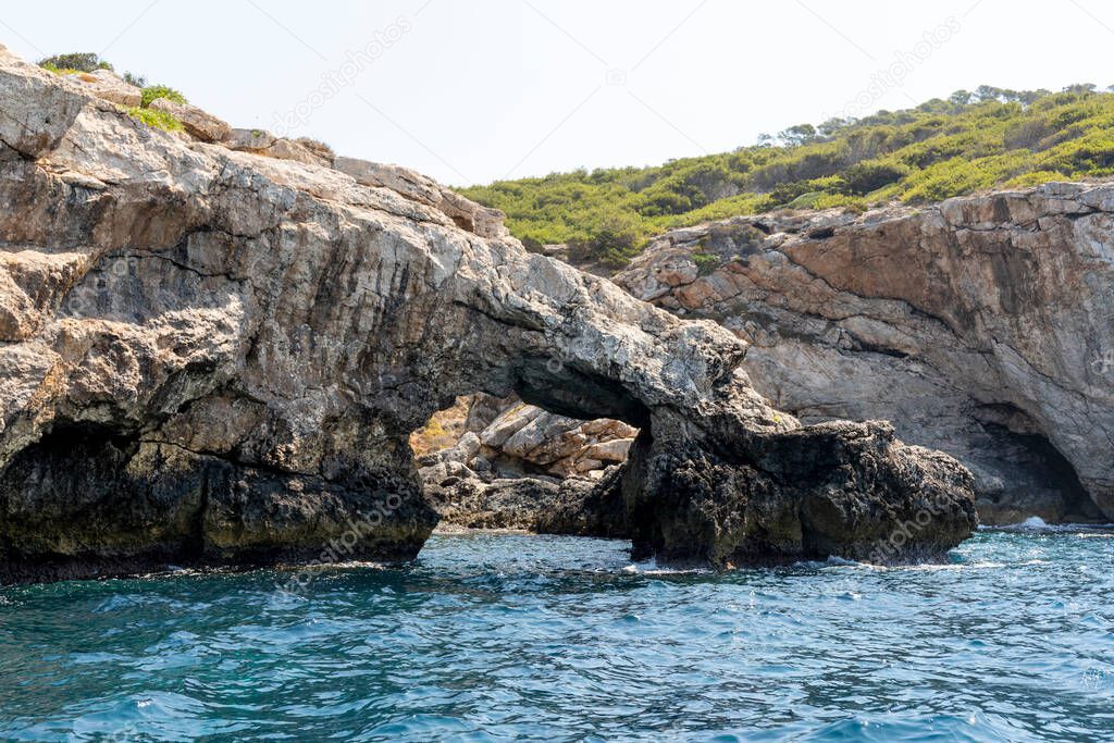 Natural arch in the limestone rock of the coast of the island of San Domino of the archipelago of the Tremiti Islands