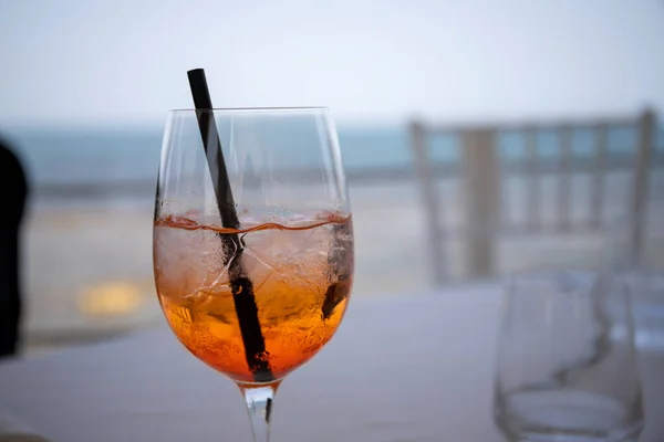 白いテーブルの前の方にスプリッツ オレンジアルコール飲料 のガラスと背景の海 — ストック写真