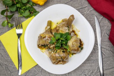 Nane aromalı Roma tarzı enginarlar. Geleneksel İtalyan mutfağı. Enginar alla Romana. Düz yatıyordu.