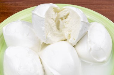 Bufalo mozzarella (mozzarella di bufala) suyla birlikte tabakta. Yakın plan. Mozzarella DOP plakayı kesti.