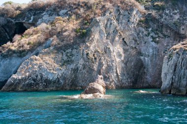 Ponza adasının kayalık uçurumunun manzarası. Orta İtalya 'nın ünlü volkanik kökenli adasının kayalık kıyısı..