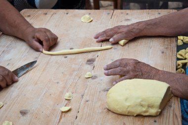 Knead the homemade orecchiette baresi. Typical fresh pasta from Bari, Puglia region, Italy. Working hands. Hands of an old woman. Italian small business owners. Ancient tradition.