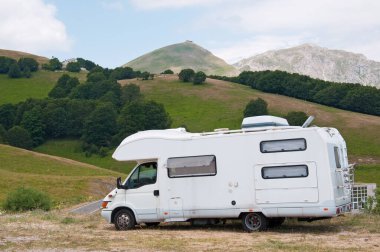 Camper holidays in the mountains in summer in Italy. Monte Terminillo in the background. Camper camping.
