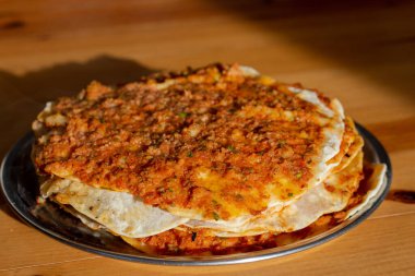 Türk pizzası ya da lahmacun ahşap bir masada kıyma ve soğandan yapılır, geleneksel lezzetli Türk mutfağı, yemek