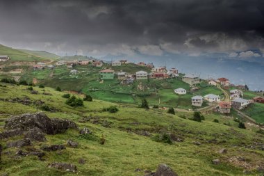 Evleri ve kara fırtına bulutlarıyla güzel köy manzarası 