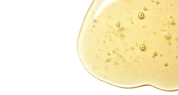 Stor storlek makro foto gul gel konsistens med bubblor. Olja för huden. Klar kosmetisk flytande gel swatch isolerad på vit bakgrund, banner format isolerad med fritt utrymme för text — Stockfoto