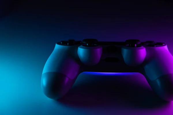 Controlador de juego, gamepad sobre fondo de neón azul y morado. macro, primer plano — Foto de Stock