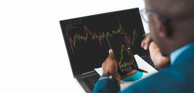 Afrikalı İşadamı Yatırım Girişimcisi Laptop Borsası Bilgi ve Ticaret grafiği üzerinde çalışıyor