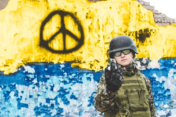 Voják s barevným balónem na pozadí symbolu míru. Zastavte válku na Ukrajině. Rusko napadlo Ukrajinu — Stock fotografie