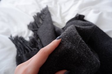 Kadın parmağı ve gri kumaş.