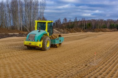 Bir yol silindiri tarafından sıkıştırılan kum