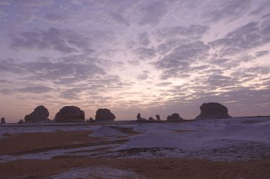 Mısır 'da beyaz çölde alacakaranlık, bulutlu gökyüzü