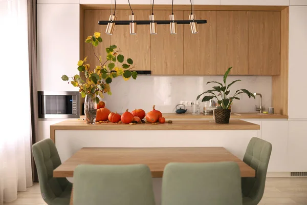 Interior moderno brillante, con cocina blanca y calabazas en una mesa. — Foto de Stock