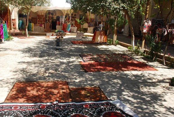 Özbekistan 'da pazar, gölgelerde halılar.