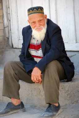 Yaşlı bir Özbek büyükbaba Taşkent 'te bir taşın üzerinde oturuyor. Özbekistan