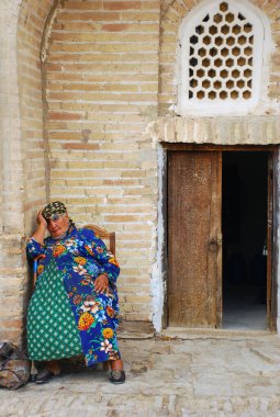 Yaşlı bir kadın ön kapının yanındaki sandalyede uyuyor. Özbekistan