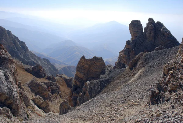 Sonbaharda Tien Shan 'daki dağların ve vadilerin arkasındaki karanlık kayalar. Özbekistan