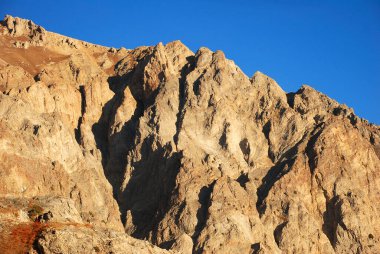 Sonbaharda Tien Shan 'daki dağlarda portakal rengi kaya zapt edilemez. Özbekistan