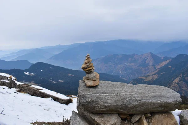 Balance rock structure on top of a mountain with panoramic view of valley in Chopta, Uttarakhand. Stone balancing.