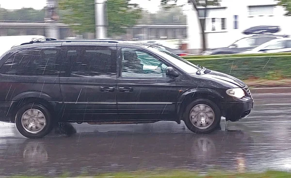 雨の中街中を車が駆け抜ける 動きのある物体を撮影するためのパンニング法 — ストック写真