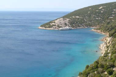 Deniz kıyılarının güzel manzarası. Doğa, manzara, turist teknesi ve kayalık plaj.