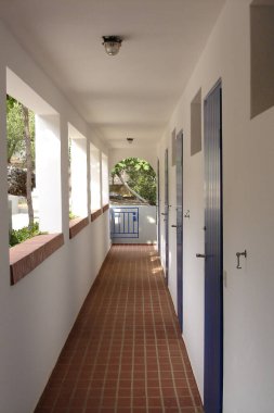 Odalara giden uzun garaj yolu ve kemerli girişi olan tatil köşkünün ayrıntıları, odaların mavi ahşap ön kapısı, kahverengi taş fayanslar, kış terası, Hırvatistan 'ın Korcula adası