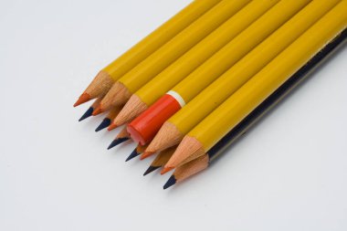 Aynı yöne bakan bir sürü sivri uçlu kalem var, ama sadece biri baş aşağı, beyaz arka planda izole edilmiş.