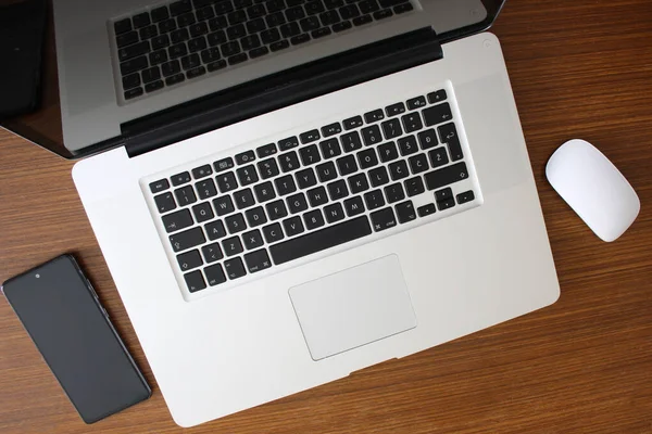 Office workspace with laptop, mouse and mobile phone