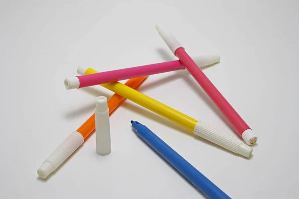 markers of different colours on a white background