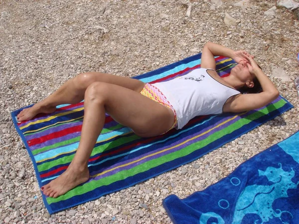 Γυναίκα Είναι Ξαπλωμένη Στην Παραλία Και Κάνει Ηλιοθεραπεία — Φωτογραφία Αρχείου