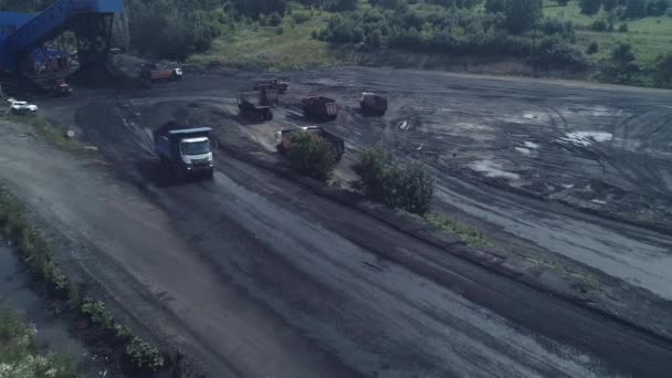 Loading trucks with coal ore. The drone flies over a heavy dump truck loaded to the brim with coal. A line of dump trucks waiting to be loaded. Mining on an industrial scale. Quarry for coal mining — Stock Video