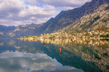 Güzel bir kış Akdeniz manzarası. Karadağ, Adriyatik Denizi. Kotor şehri yakınlarındaki Kotor Körfezi manzarası. Dağlar ve bulutlar suya yansıyor