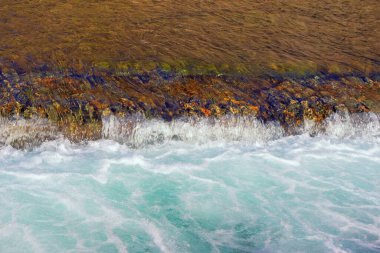 Soyut doğal arkaplan. Renk ve doku zıtlıkları. Nehirde akan su ve eşik, beyaz su