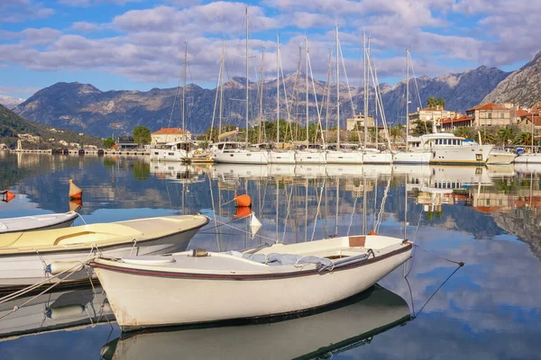 Güneşli kış gününde güzel Akdeniz manzarası. Balıkçı tekneleri ve yatlar suya yansıyor. Karadağ, Kotor Körfezi. Eski Kotor Kasabası yakınlarındaki marina manzarası