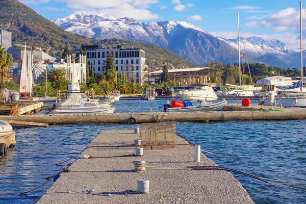 Tivat, Karadağ - 13 Aralık 2021: Kotor Körfezi manzarası ve güneşli kış gününde Lovcen dağları. Seljanovo köyü yakınlarındaki küçük marinada yatlar ve tekneler.