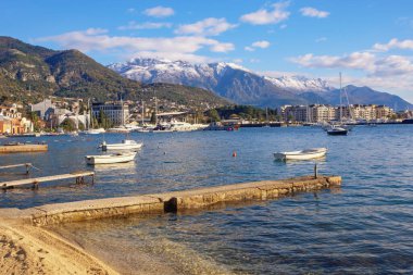 Güneşli kış gününde güzel Akdeniz manzarası. Karadağ, Adriyatik Denizi. Tivat kenti yakınlarındaki Kotor Körfezi manzarası ve uzaktaki Lovcen dağları karla kaplı.