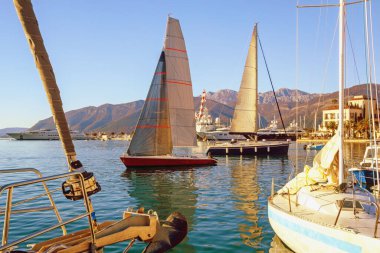 Sudaki yelkenliler. Kotor Körfezi, Tivat kenti ve Porto Karadağ marinasının kış manzarası. Karadağ