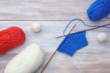 Hobi konsepti. Köy masasında örülmemiş örgü şişleri ve tüy yumaklarıyla. Boşluğu kopyala