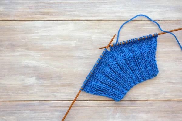 Hobi konsepti. Köy masasında örgü iğneleriyle tamamlanmamış örgü. Metin için boşluk