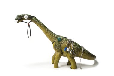 Vücudunda ve ağzında mücevherler olan Brontosaurus oyuncağı. Beyaz arka planda doğal gölgeyle izole edilmiş..