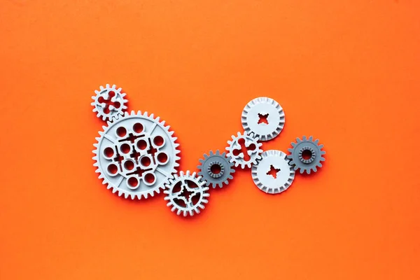 Turuncu arka planda çark mekanizması. konsept dişliler çalışıyor