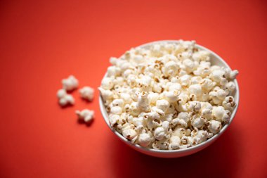 Kırmızı arka planda bir kase patlamış mısır. resim bulanık efektli