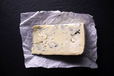Siyah arka planda bir dilim Gorgonzola peyniri. Piedmont bölgesinden tipik İtalyan peyniri.