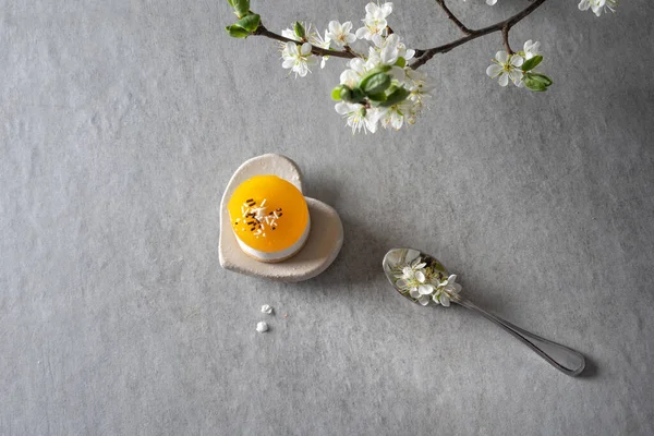 灰色の床にレモンゼリーのミニケーキの詳細 スプーンに梅の花と枝 — ストック写真