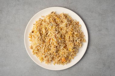 Gri taş arka planda biryani pilav tabağı. tepeden görünüm