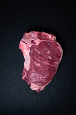 İnek bifteği. Sığır eti. Esmer arka planda biftek. Koyu arkaplanı olan çiğ et.