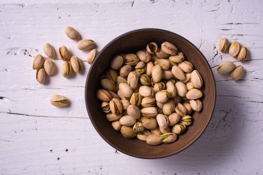 Beyaz ahşap masada fıstıklı en iyi manzara kasesi.