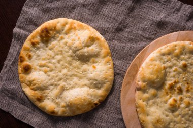 Tipik Asya Naan ekmeği, keten peçetenin üzerindeki ahşap masada. Yukarıdan görüntüle